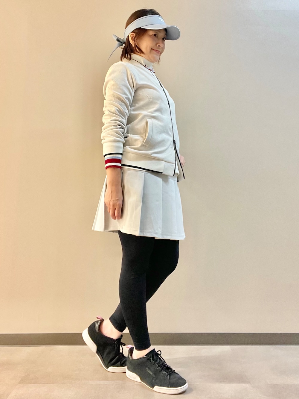 ホワイト系のブルゾン、ホワイト系のTシャツ/カットソー、グレー系のスカートを着用したレディースの秋コーディネートの2枚目の写真
