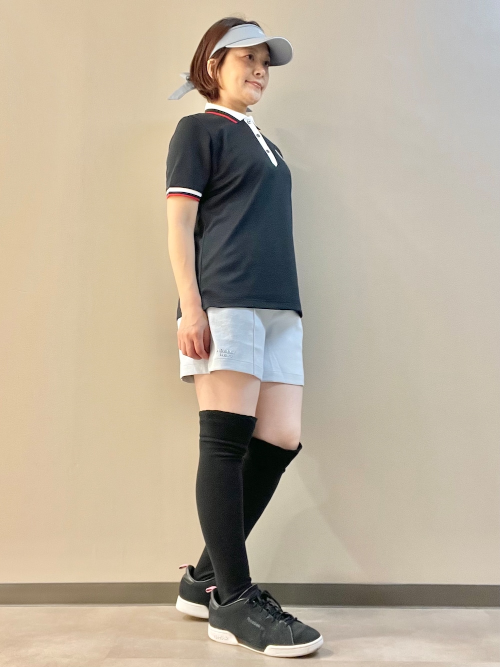 ブラック系のポロシャツ、ブルー系のその他パンツ、ブラック系のトートバッグを着用したレディースの夏コーディネートの2枚目の写真