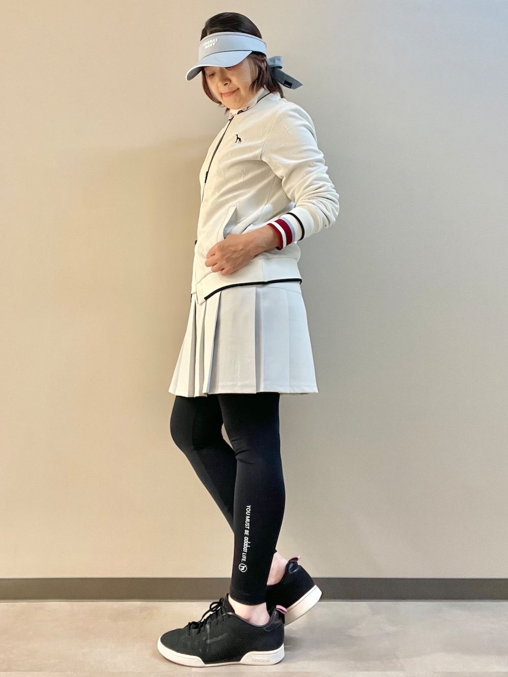 ホワイト系のブルゾン、ホワイト系のTシャツ/カットソー、グレー系のスカートを着用したレディースの秋コーディネートの4枚目の写真