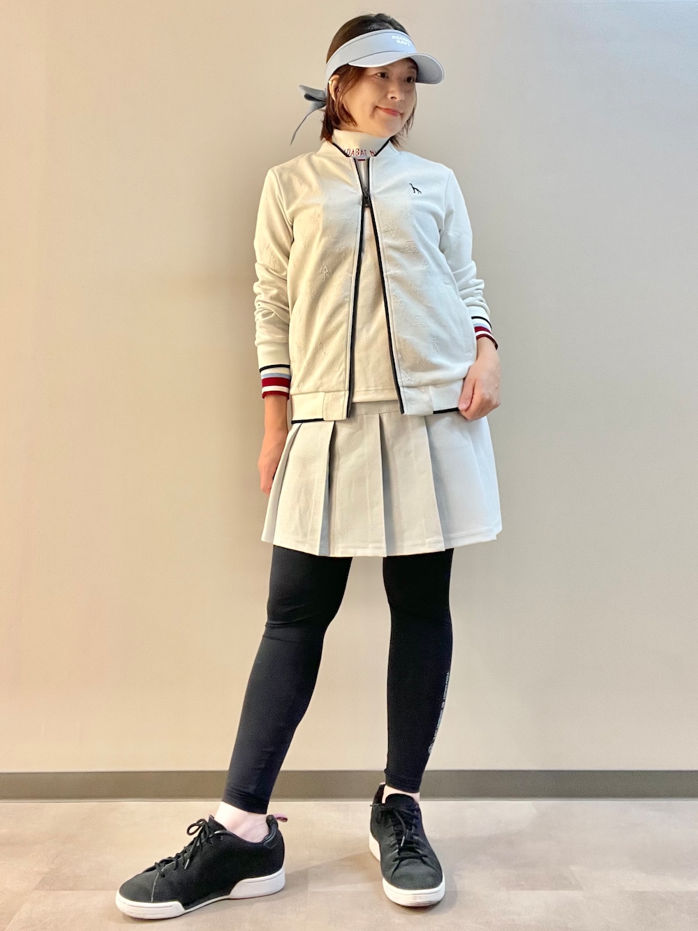 ホワイト系のブルゾン、ホワイト系のTシャツ/カットソー、グレー系のスカートを着用したレディースの秋コーディネートの6枚目の写真