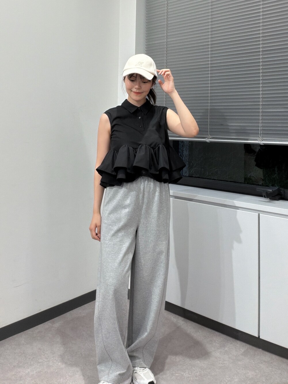 グレー系のその他パンツ、ブラック系のシャツ/ブラウス、ホワイト系のキャップを着用したレディースの夏コーディネートの2枚目の写真
