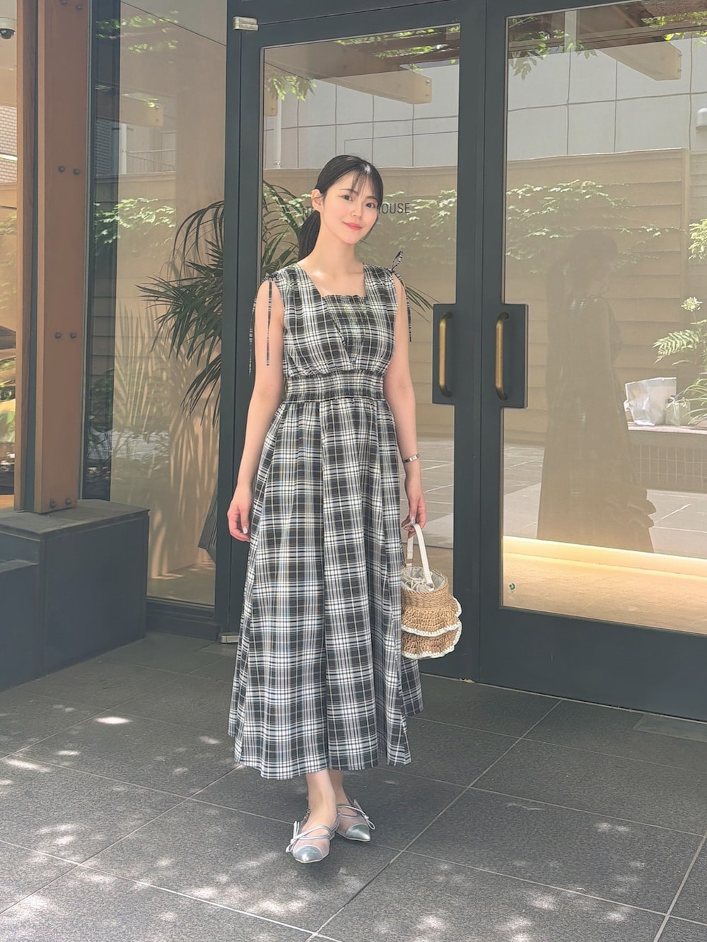 ブラック系のワンピース、シルバー系のパンプス、ベージュ系のショルダーバッグを着用したレディースの夏コーディネートの3枚目の写真