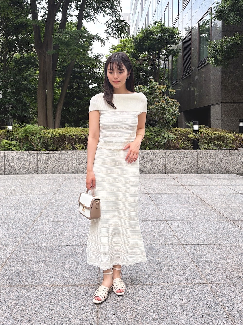 ホワイト系のワンピース、ホワイト系のパンプス、グレー系のショルダーバッグを着用したレディースの夏コーディネートの3枚目の写真