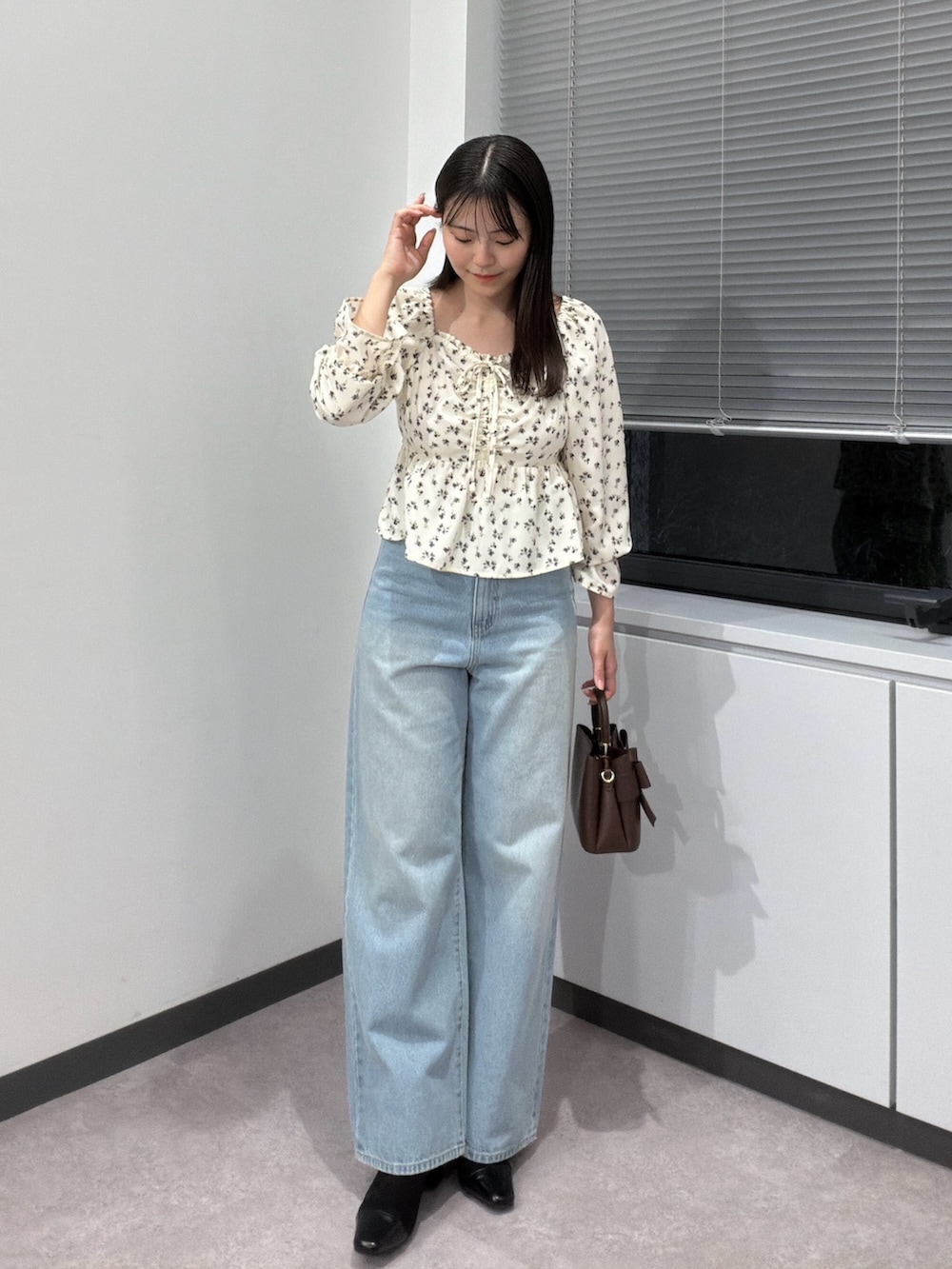 ホワイト系のシャツ/ブラウス、ブラウン系のショルダーバッグ、ブルー系のデニムパンツを着用したレディースの秋コーディネートの3枚目の写真