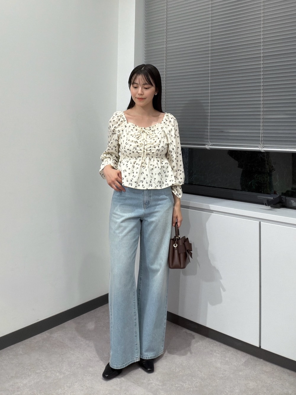 ホワイト系のシャツ/ブラウス、ブラウン系のショルダーバッグ、ブルー系のデニムパンツを着用したレディースの秋コーディネートの2枚目の写真