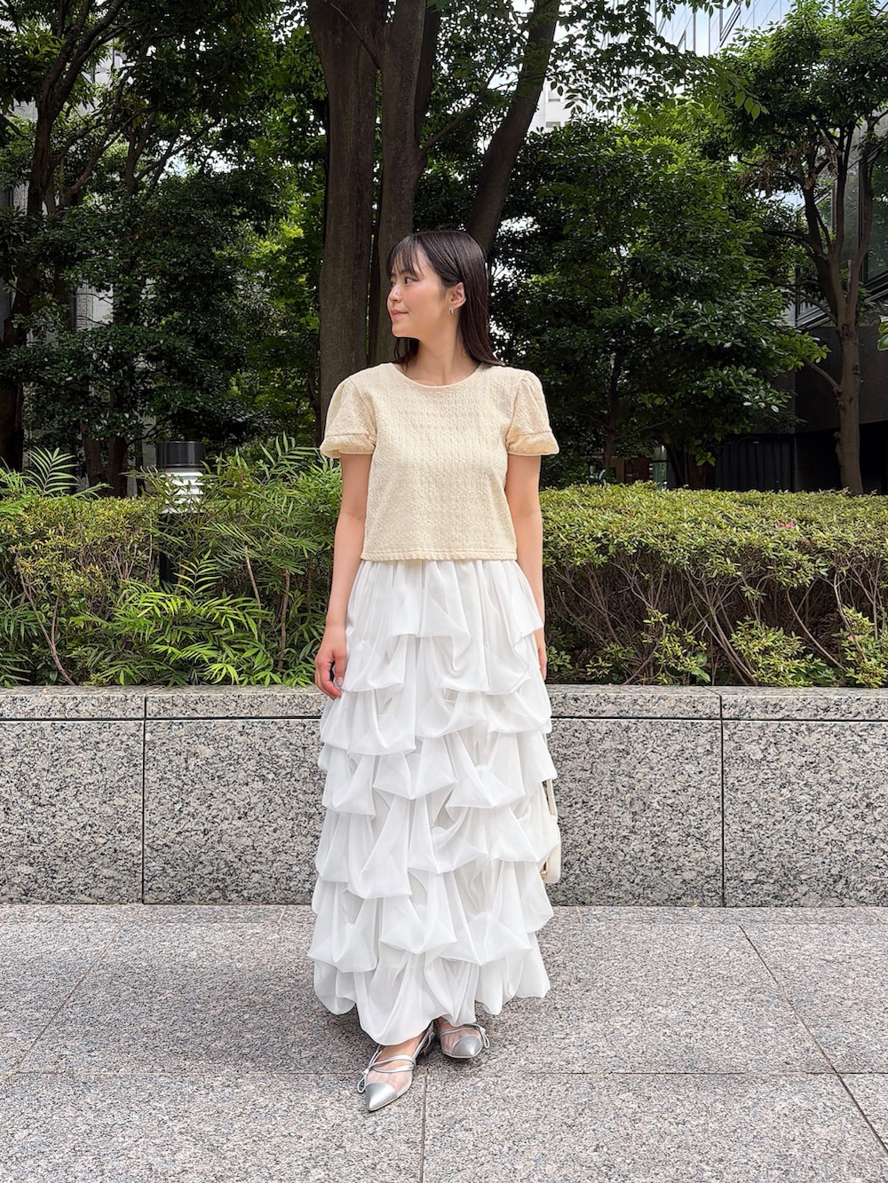 ホワイト系のスカート、イエロー系のTシャツ/カットソー、ホワイト系のショルダーバッグを着用したレディースの夏コーディネートの2枚目の写真