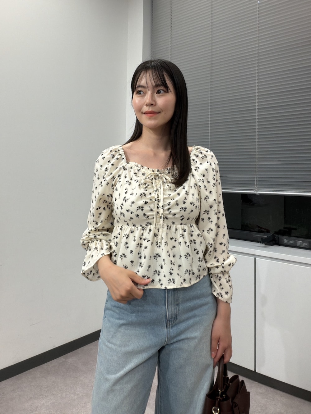 ホワイト系のシャツ/ブラウス、ブラウン系のショルダーバッグ、ブルー系のデニムパンツを着用したレディースの秋コーディネートの5枚目の写真
