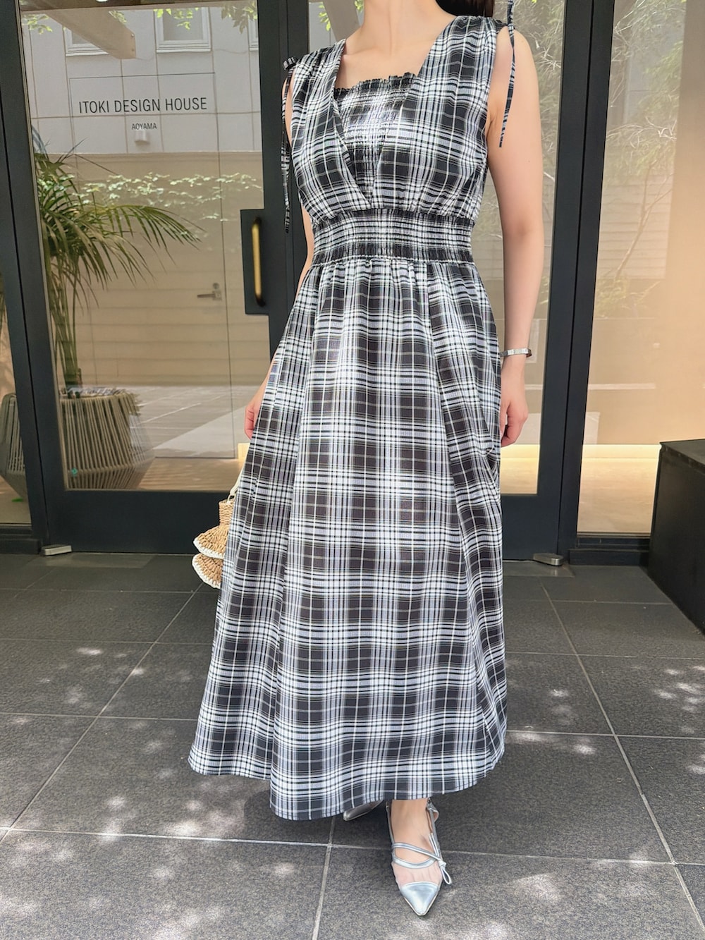 ブラック系のワンピース、シルバー系のパンプス、ベージュ系のショルダーバッグを着用したレディースの夏コーディネートの4枚目の写真