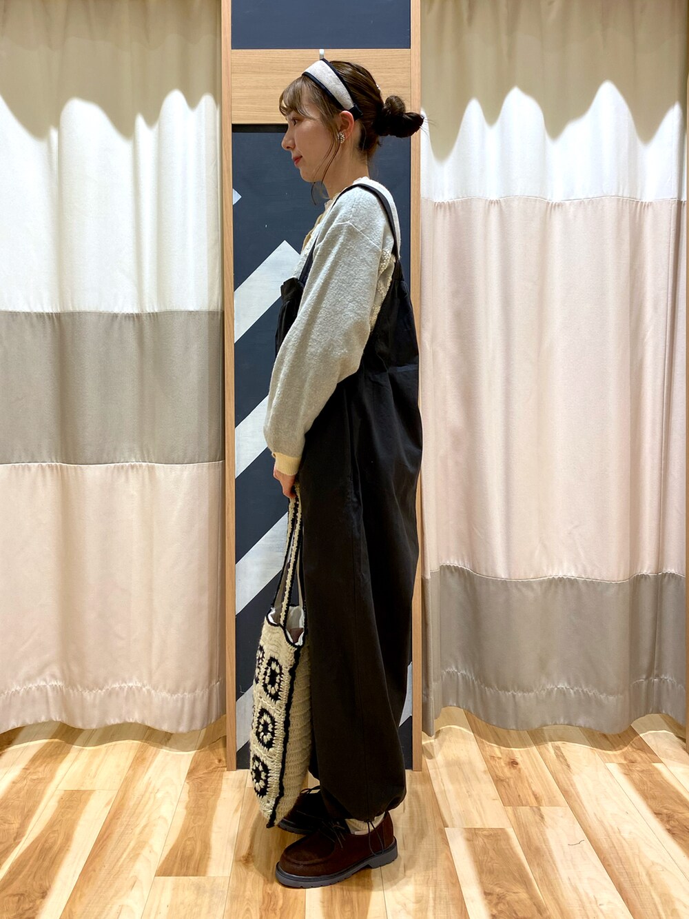 グレー系のサロペット/オーバーオール、グリーン系のカーディガン/ボレロ、ホワイト系のTシャツ/カットソーを着用したレディースの冬コーディネートの2枚目の写真