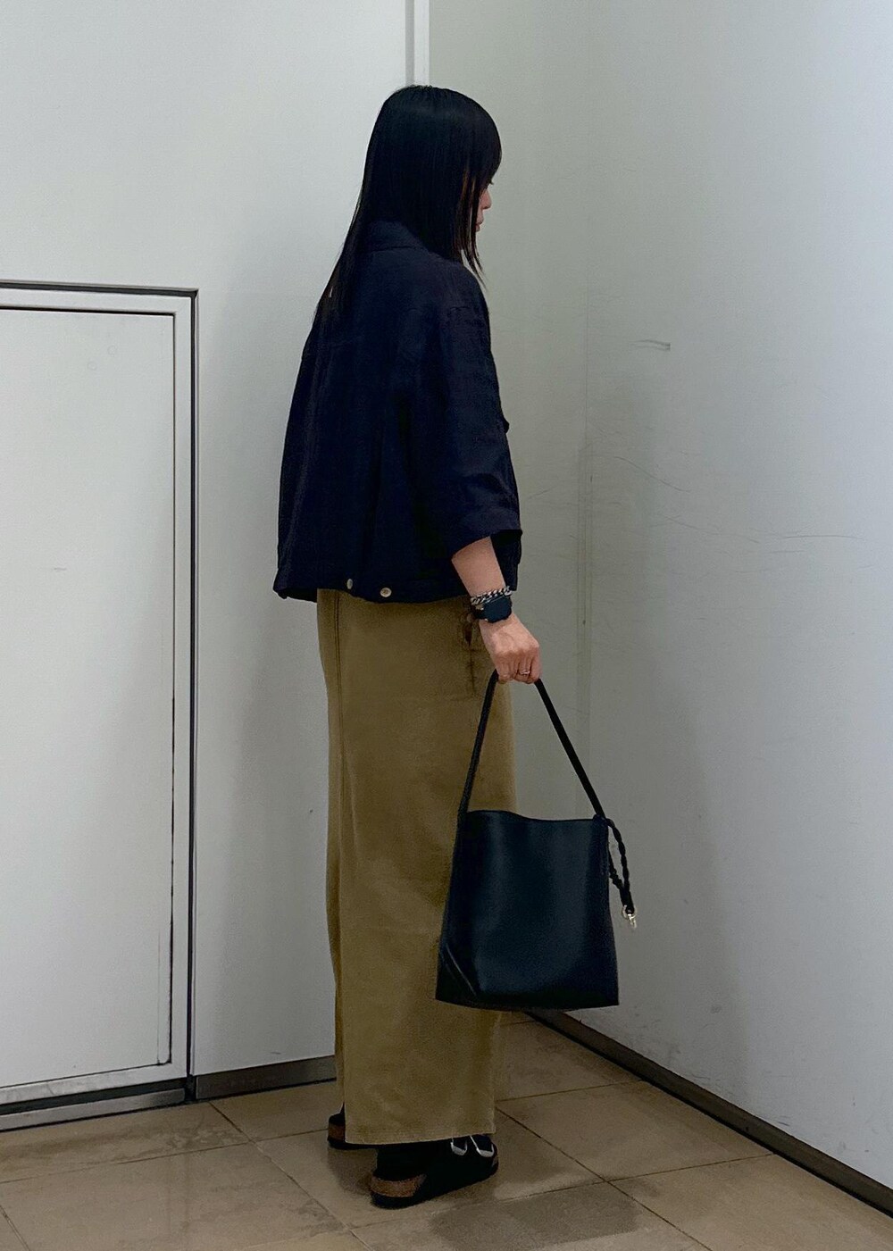 ブラック系のショルダーバッグ、ブラウン系のワンピース、ブラック系のサンダルを着用したレディースの夏コーディネートの4枚目の写真