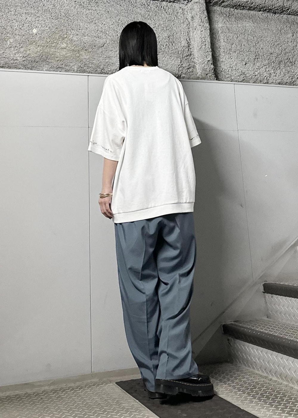 ホワイト系のTシャツ/カットソー、グリーン系のスラックス、シルバー系のバングル/リストバンドを着用したレディースの春コーディネートの3枚目の写真