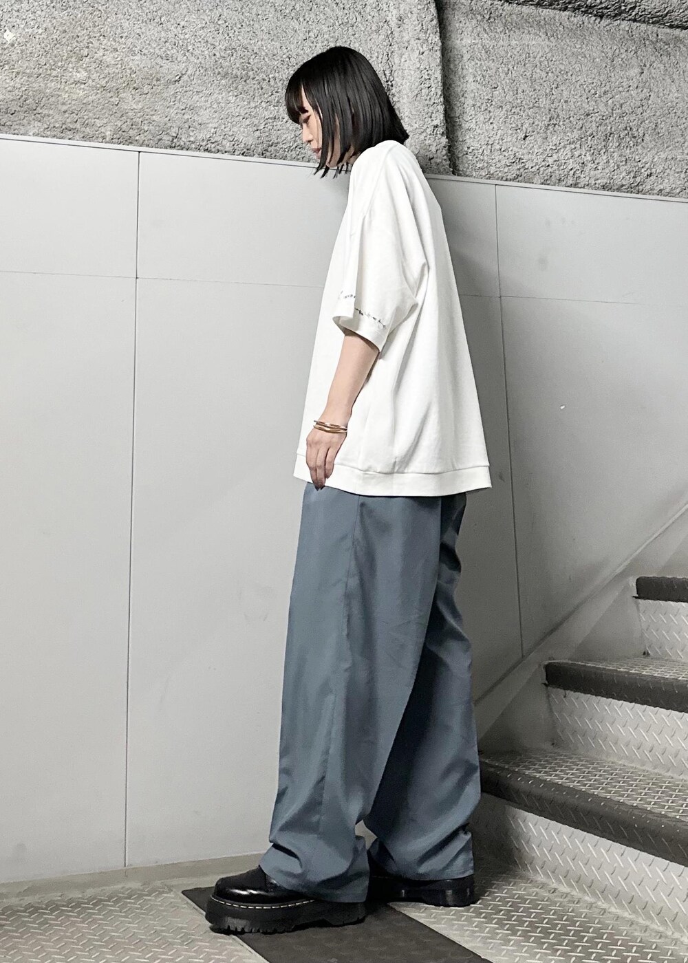 ホワイト系のTシャツ/カットソー、グリーン系のスラックス、シルバー系のバングル/リストバンドを着用したレディースの春コーディネートの2枚目の写真