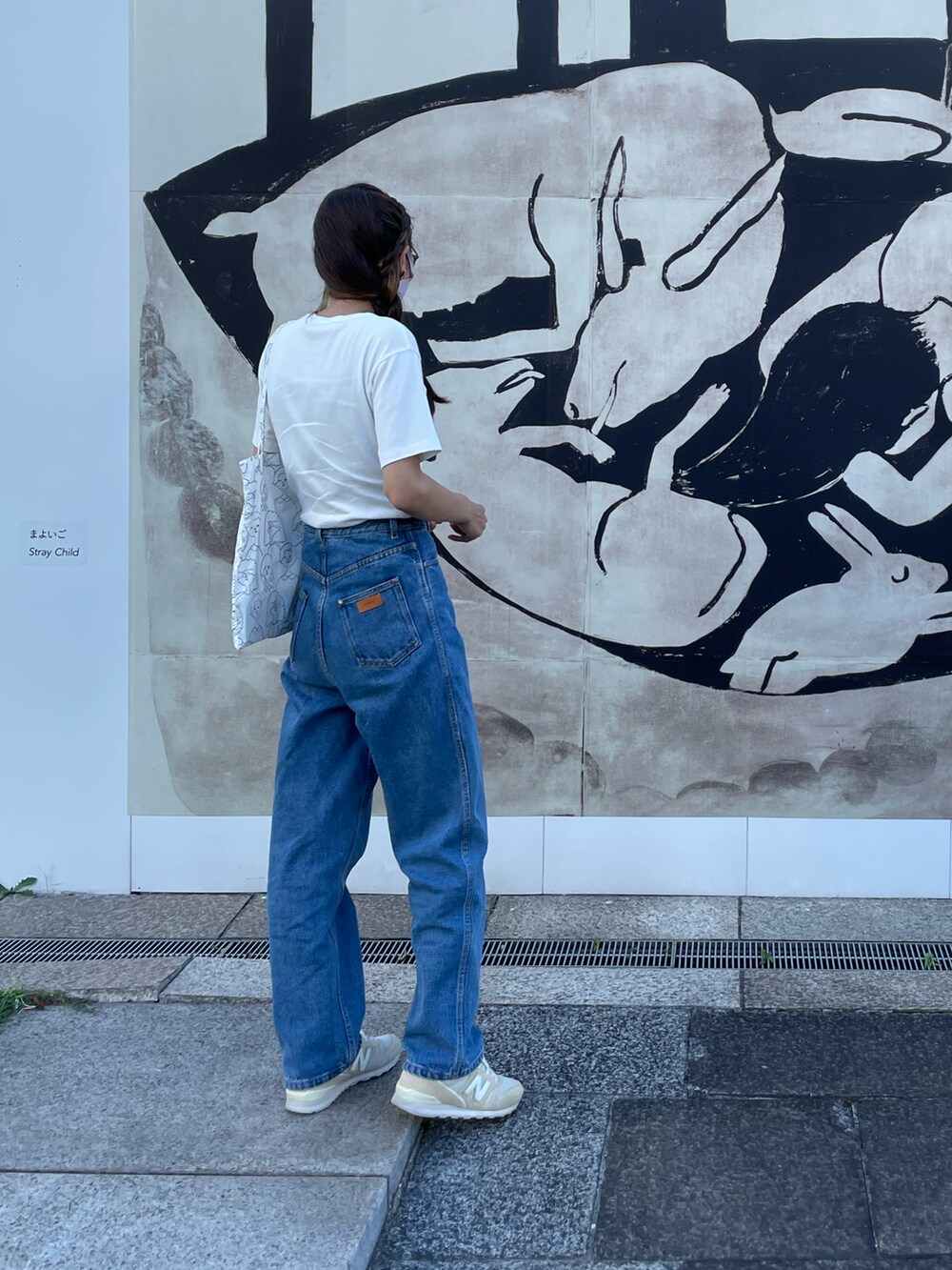 ブルー系のデニムパンツ、ホワイト系のTシャツ/カットソー、ベージュ系のスニーカーを着用したレディースの秋コーディネートの2枚目の写真