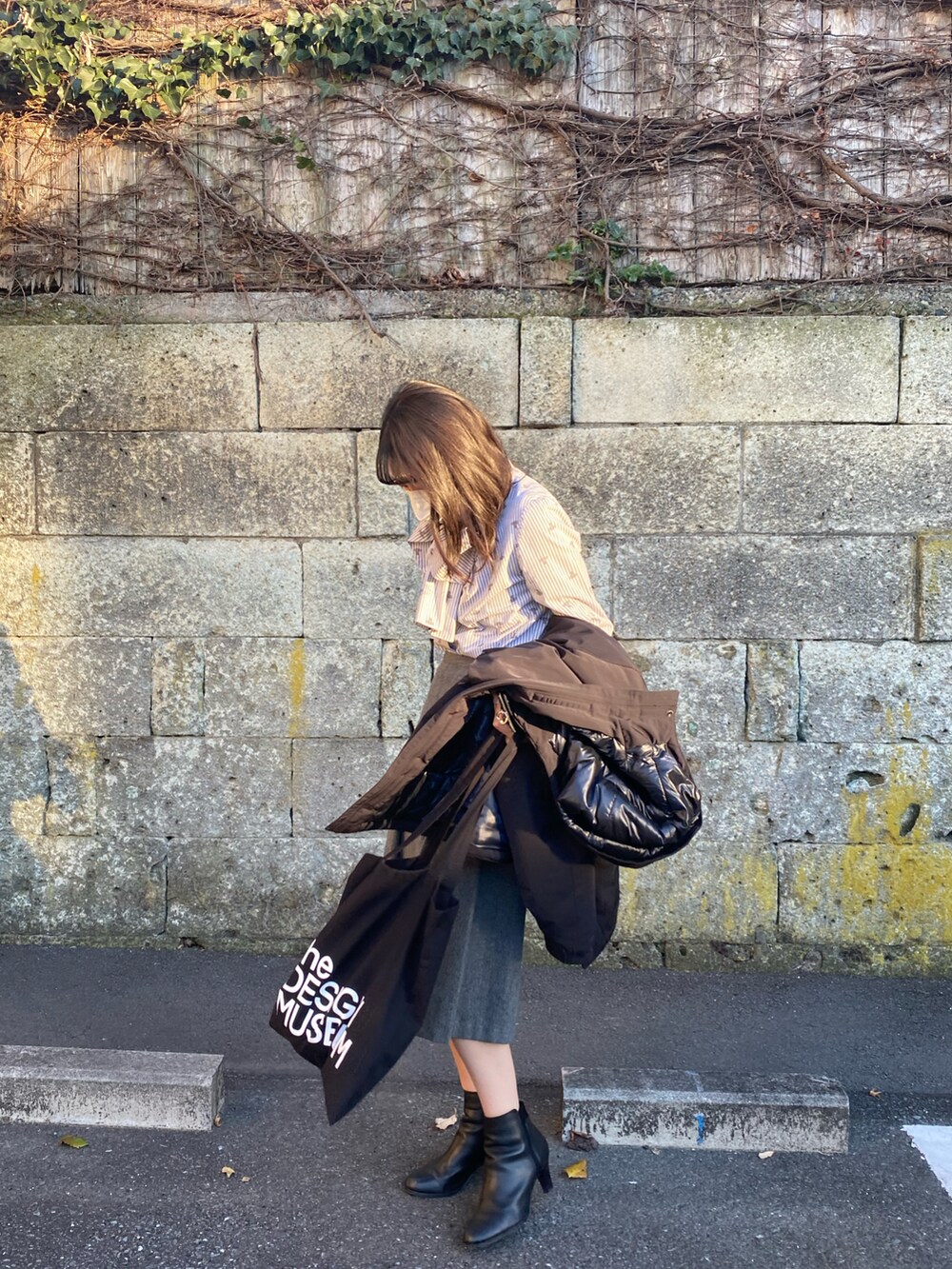 グレー系のシャツ/ブラウス、ブラック系のブーツ、ブラック系のダウンジャケット/コートを着用したレディースの冬コーディネートの2枚目の写真