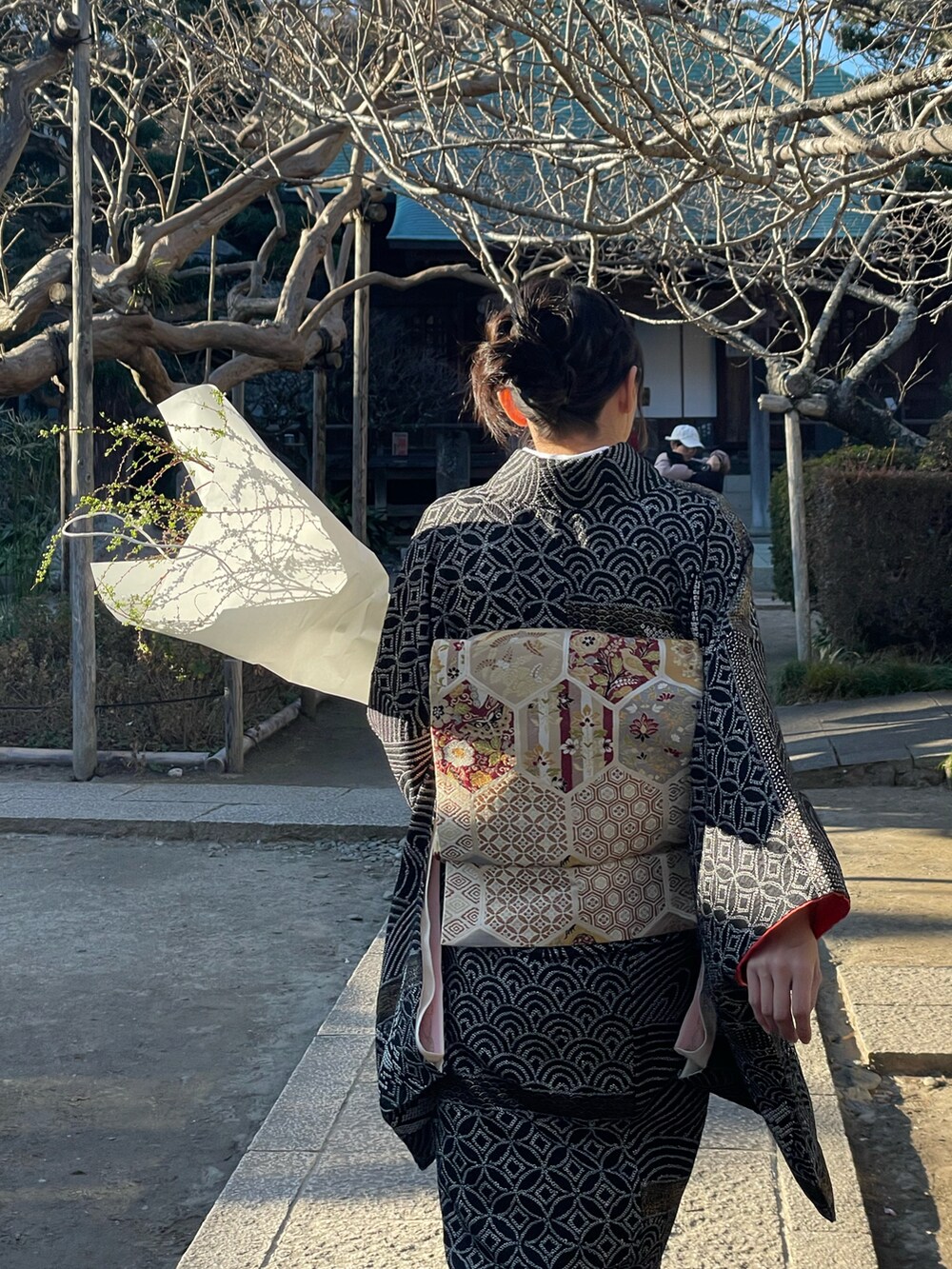 ブラック系のブーツ、ブラック系の着物、ゴールド系の着物を着用したレディースの冬コーディネートの3枚目の写真