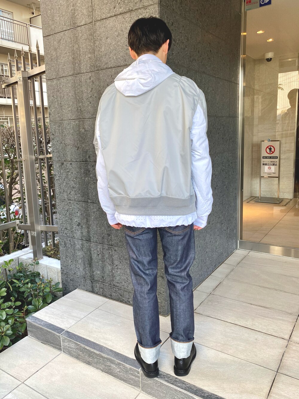 ブラック系のローファー、ホワイト系のMA-1、ブルー系のデニムパンツを着用したメンズの冬コーディネートの2枚目の写真