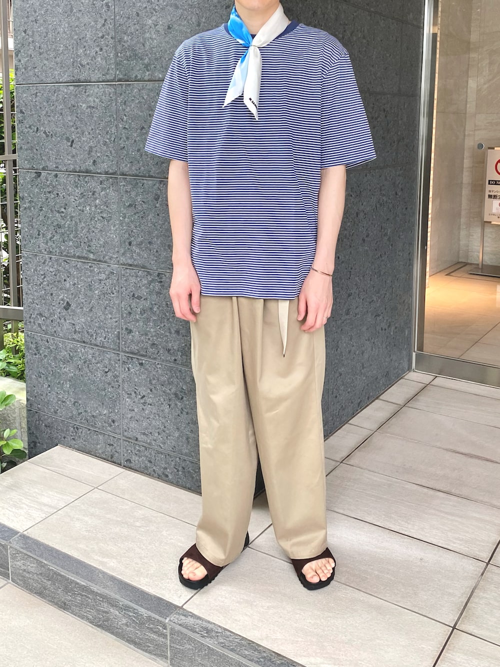 ブルー系のTシャツ/カットソー、グリーン系のチノパンツ、ホワイト系のバンダナ/スカーフを着用したメンズの夏コーディネートの2枚目の写真