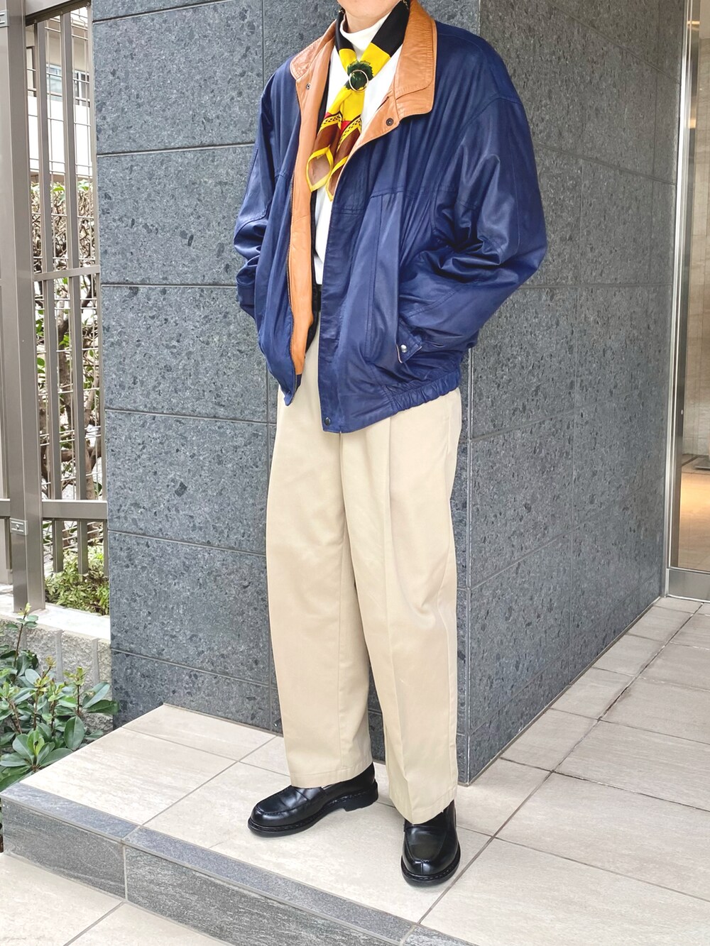 ブルー系のブルゾン、ホワイト系のTシャツ/カットソー、ベージュ系のスラックスを着用したメンズの秋コーディネートの2枚目の写真