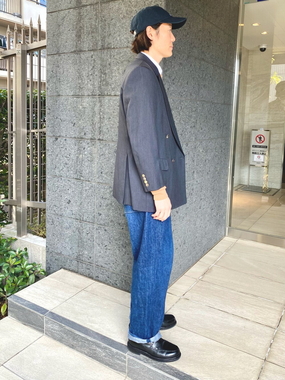 ブルー系のテーラードジャケット、ブラウン系のニット/セーター、ブルー系のデニムパンツを着用したメンズの冬コーディネートの3枚目の写真