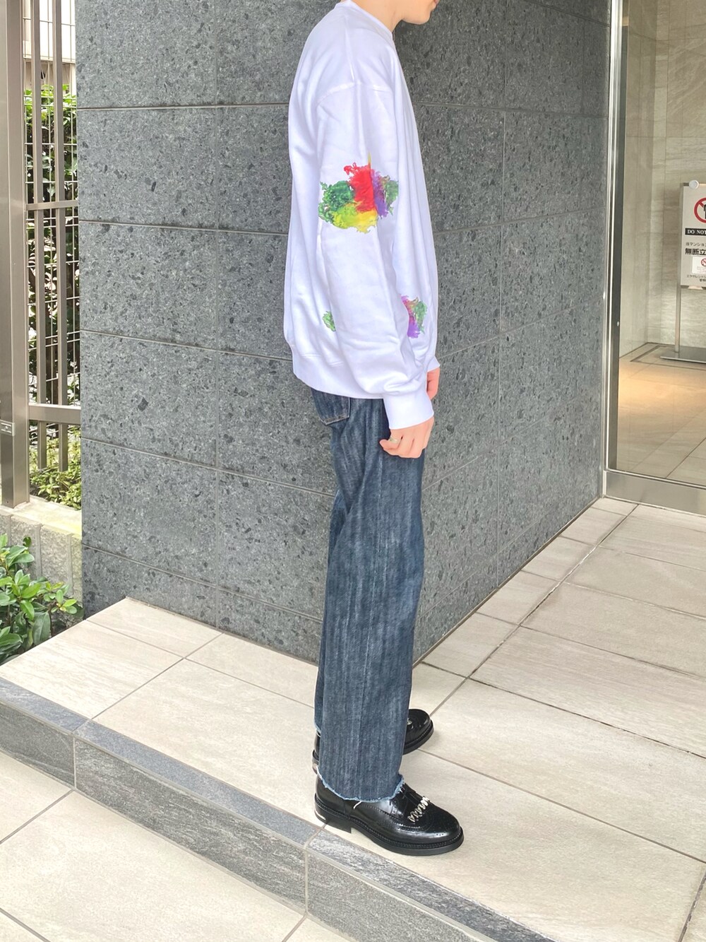 ホワイト系のスウェット、ブルー系のデニムパンツ、ブラック系のシューズを着用したメンズの秋コーディネートの3枚目の写真