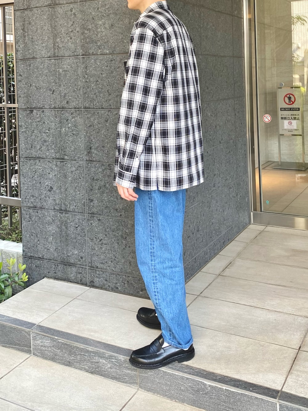 ブラック系のシャツ/ブラウス、ブルー系のデニムパンツ、ブラック系のローファーを着用したメンズの春コーディネートの2枚目の写真