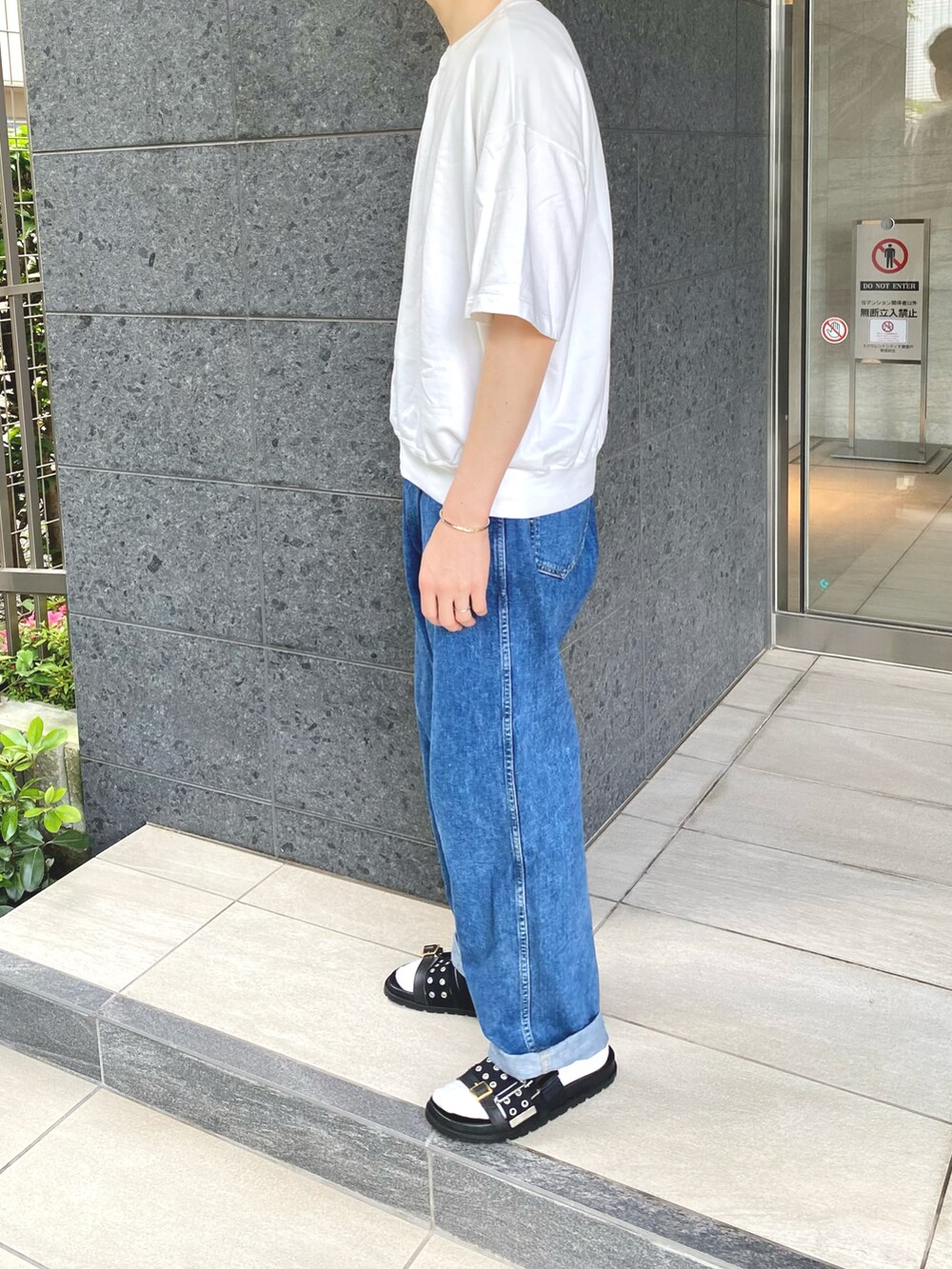ホワイト系のTシャツ/カットソー、ブルー系のデニムパンツ、ブラック系のサンダルを着用したメンズの夏コーディネートの3枚目の写真