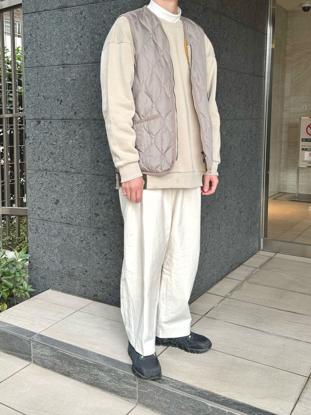 ベージュ系のスウェット、ベージュ系のダウンベスト、ホワイト系のTシャツ/カットソーを着用したメンズの冬コーディネートの3枚目の写真