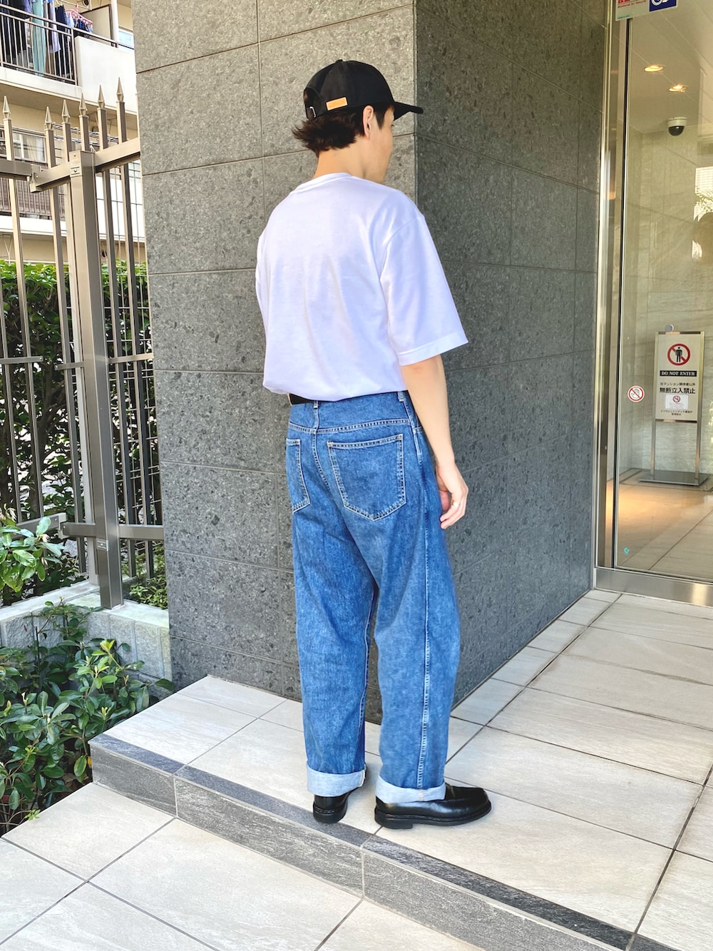 ホワイト系のTシャツ/カットソー、ブルー系のデニムパンツ、ブラック系のローファーを着用したメンズの秋コーディネートの2枚目の写真