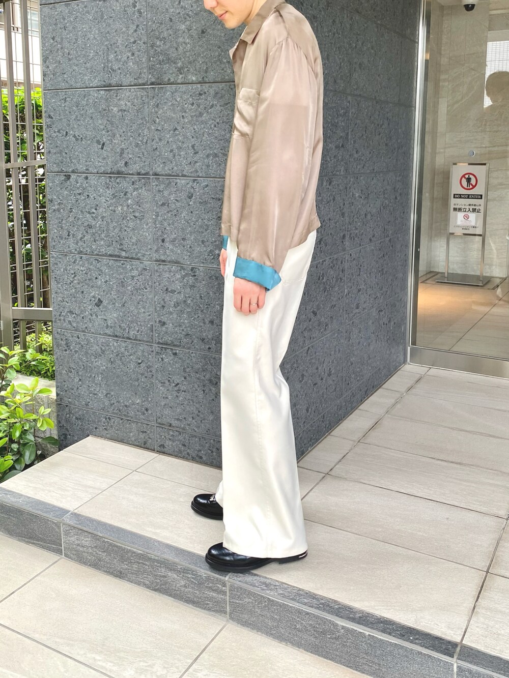 ブラウン系のシャツ/ブラウス、ホワイト系のスラックス、ブラック系のシューズを着用したメンズの春コーディネートの2枚目の写真