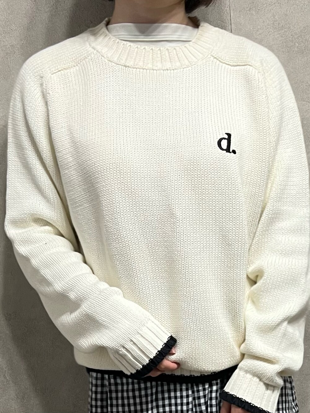 ホワイト系のニット/セーター、ブラック系のスカートを着用したレディースの春コーディネートの2枚目の写真