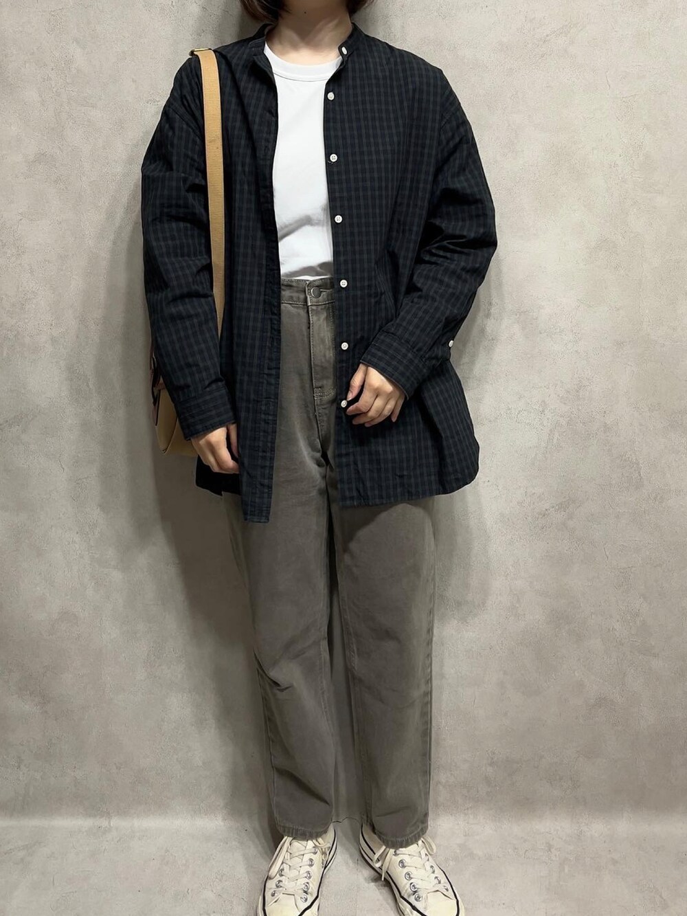 ブラック系のシャツ/ブラウス、グレー系のパンツを着用したレディースの春コーディネートの2枚目の写真