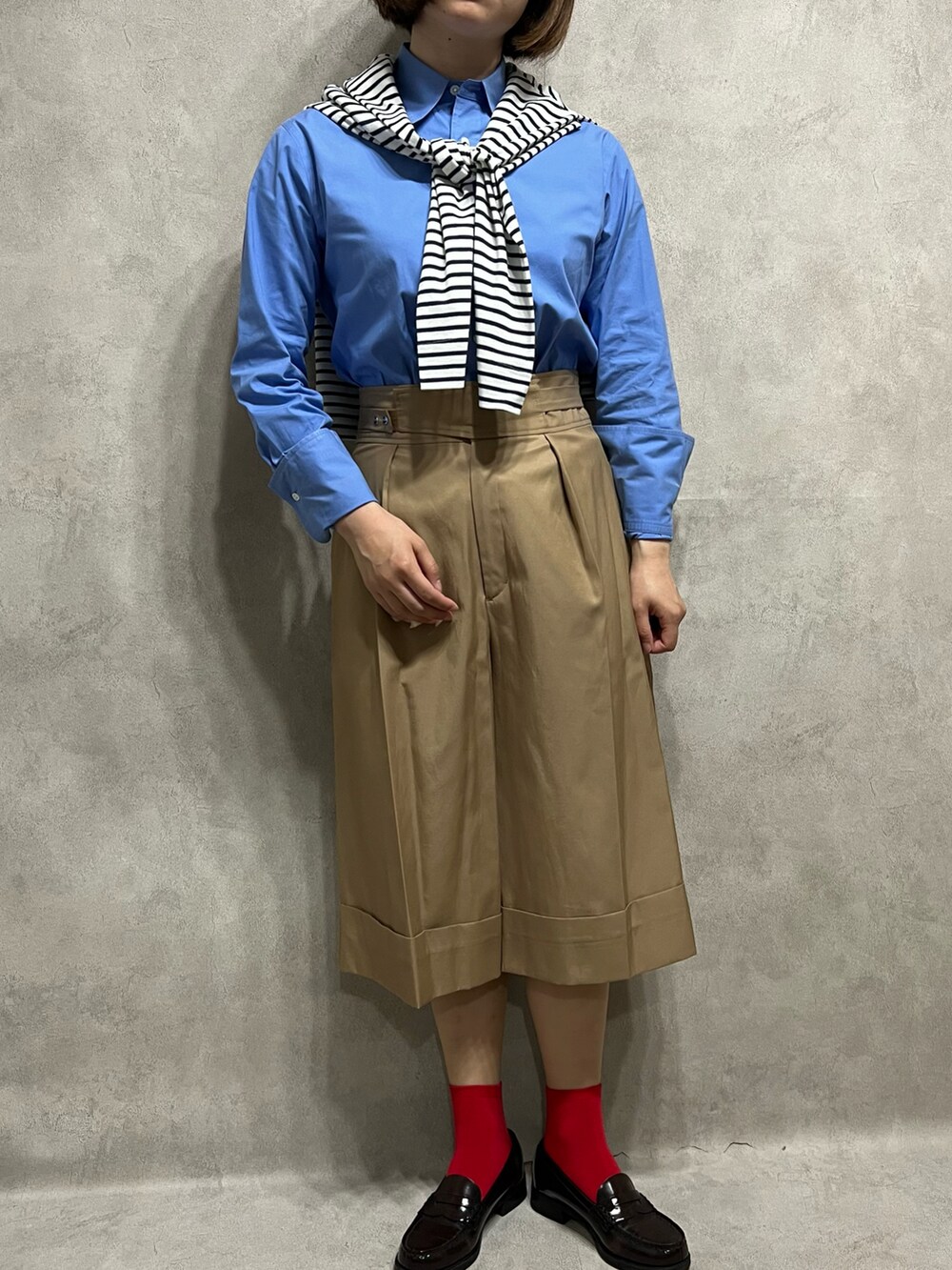 ブルー系のシャツ/ブラウス、ベージュ系のパンツを着用したレディースの春コーディネートの2枚目の写真