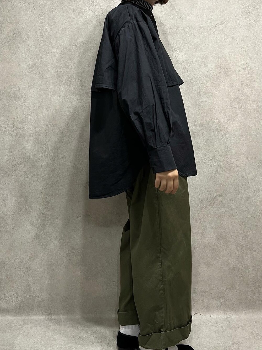 ブラック系のシャツ/ブラウス、グリーン系のパンツを着用したレディースの春コーディネートの2枚目の写真