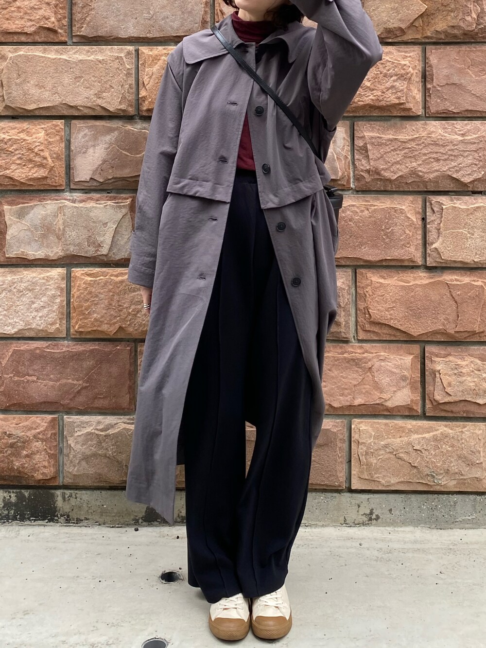 ブラック系のトートバッグ、グレー系のトレンチコートを着用したレディースの冬コーディネートの2枚目の写真