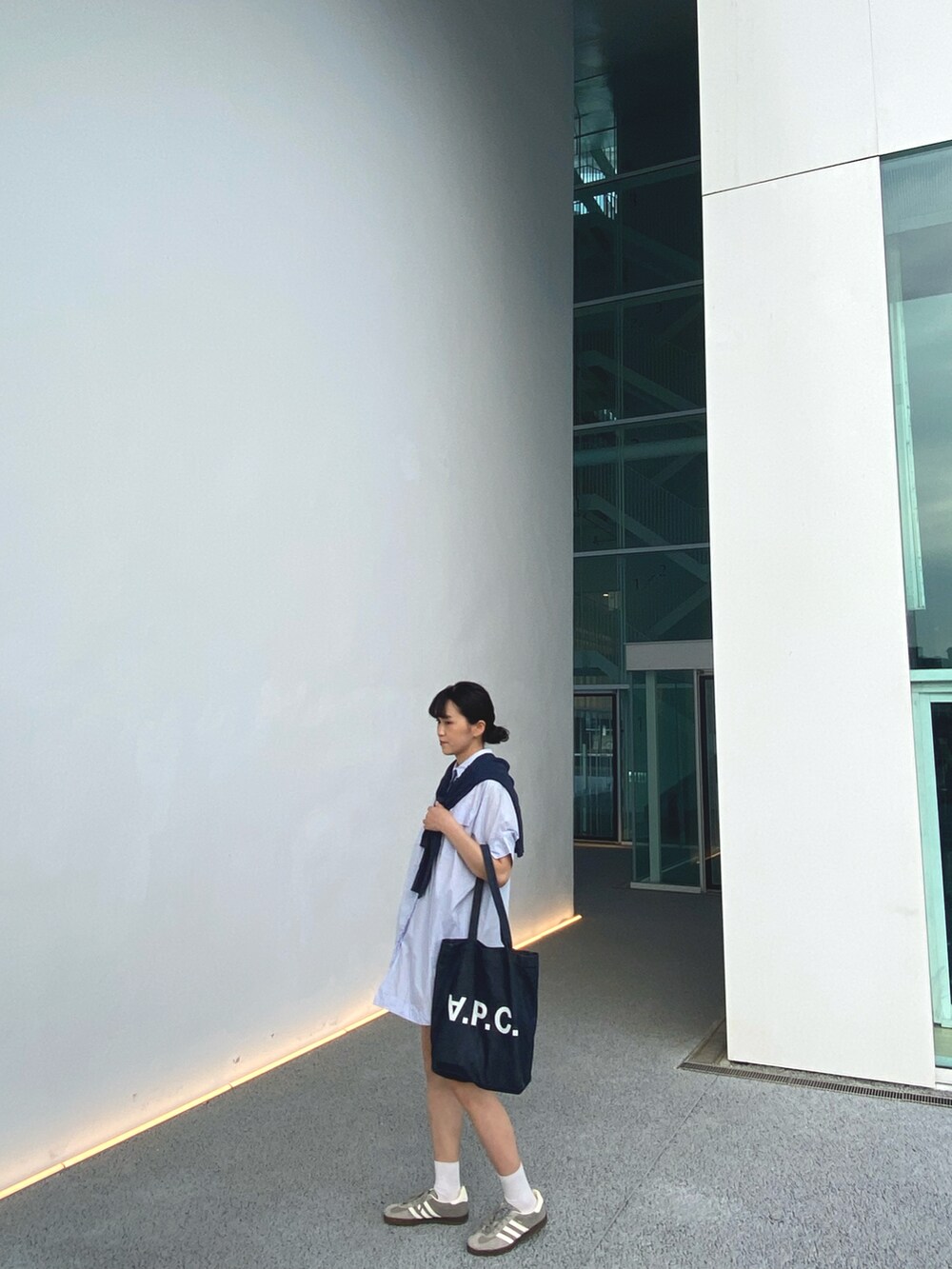 ブルー系のトートバッグ、グレー系のシューズを着用したレディースの春コーディネートの2枚目の写真