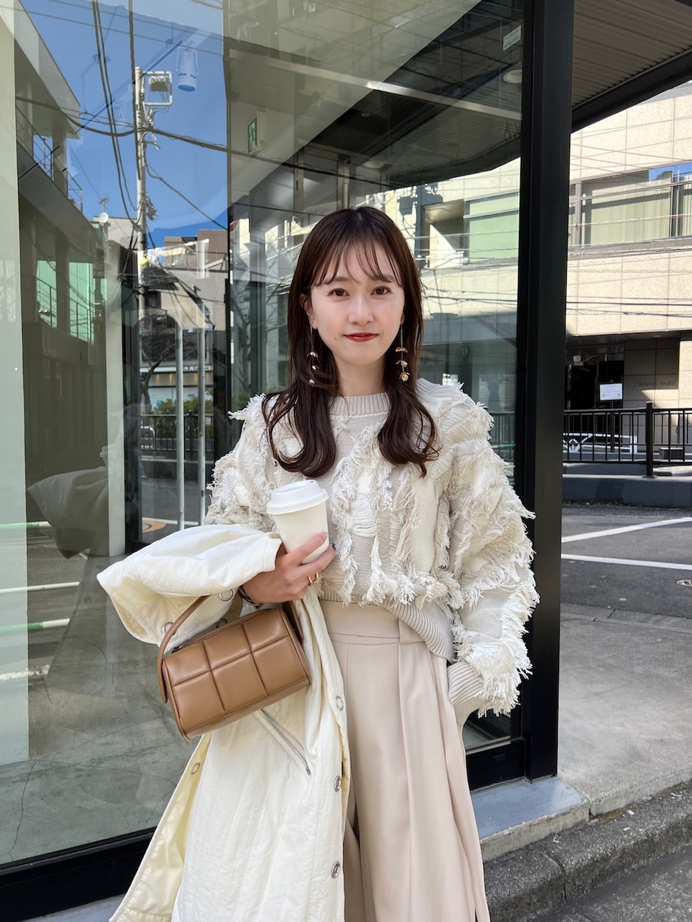 ホワイト系のニット/セーター、ホワイト系のパンツ、ブラック系のブーツを着用したレディースの冬コーディネートの2枚目の写真