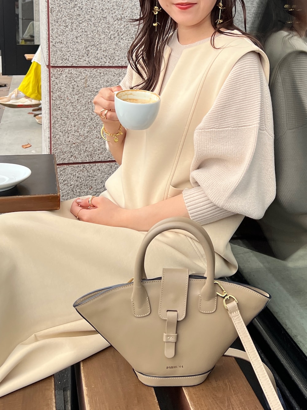 ベージュ系のワンピース、ベージュ系のニット/セーター、ブラック系のブーツを着用したレディースの秋コーディネートの2枚目の写真