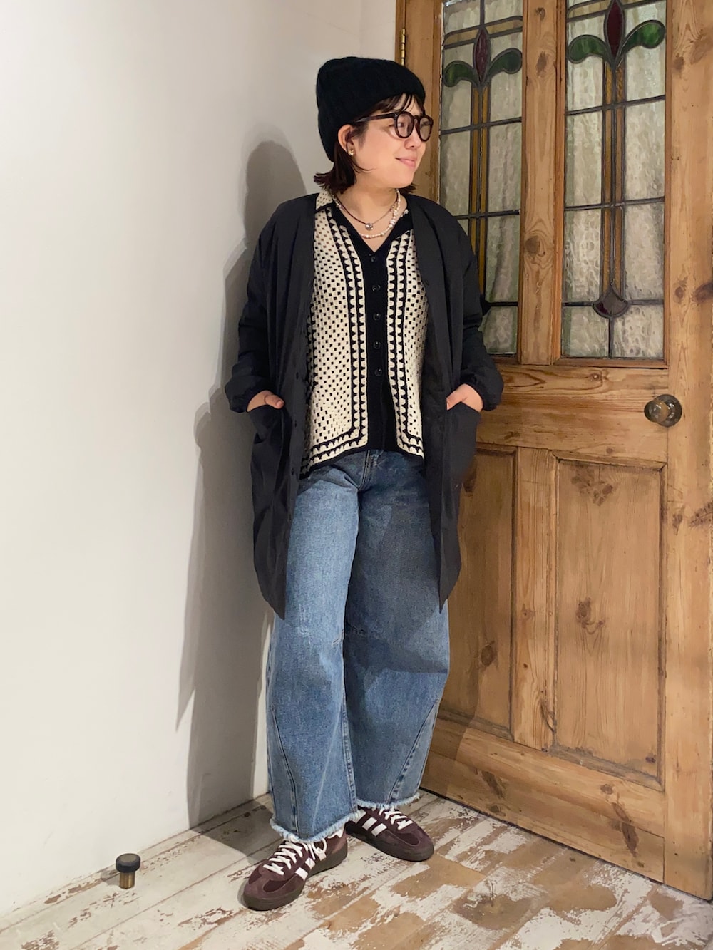 ホワイト系のカーディガン/ボレロ、ブラック系のダウンジャケット/コート、ブルー系のデニムパンツを着用したレディースの秋コーディネートの2枚目の写真