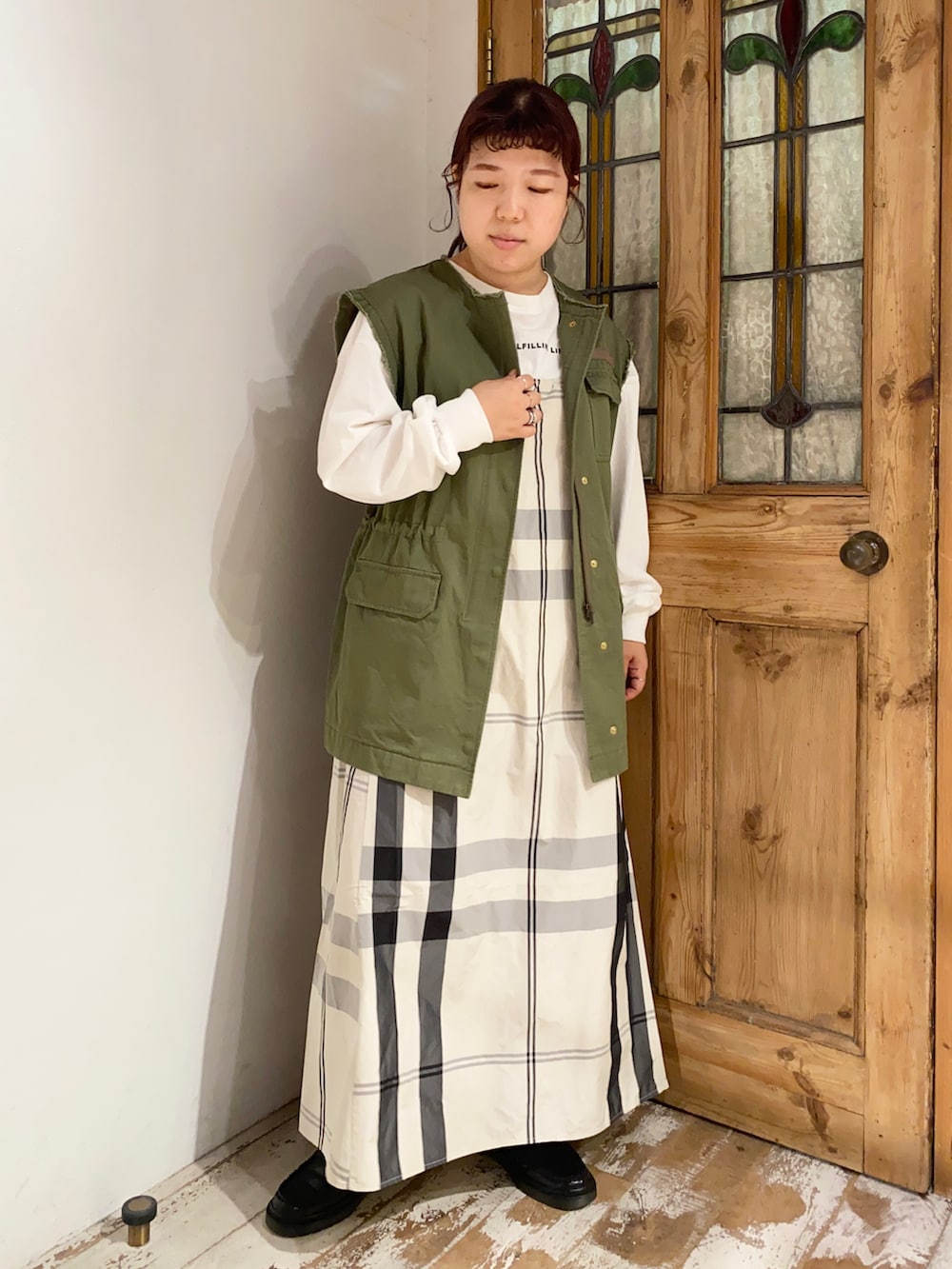 グリーン系のミリタリージャケット、ベージュ系のワンピース、ブラック系のローファーを着用したレディースの秋コーディネートの3枚目の写真