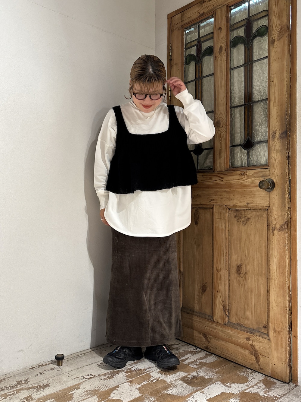 ブラック系のベスト、ホワイト系のTシャツ/カットソー、グリーン系のスカートを着用したレディースの秋コーディネートの2枚目の写真