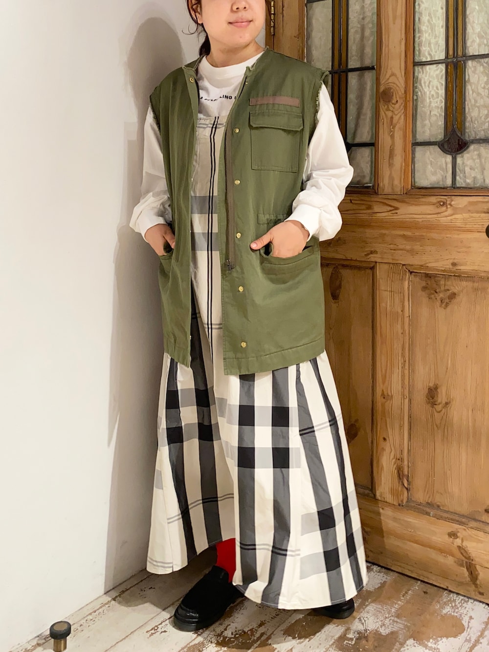 グリーン系のミリタリージャケット、ベージュ系のワンピース、ブラック系のローファーを着用したレディースの秋コーディネートの2枚目の写真