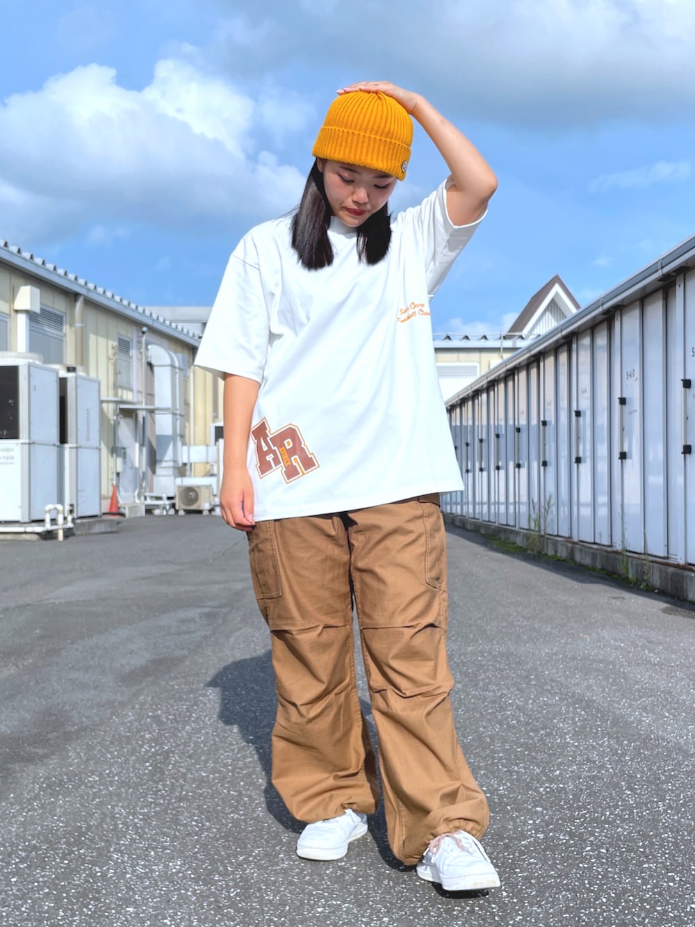 ホワイト系のTシャツ/カットソー、ブラウン系のカーゴパンツ、イエロー系のニットキャップ/ビーニーを着用したレディースの夏コーディネートの2枚目の写真