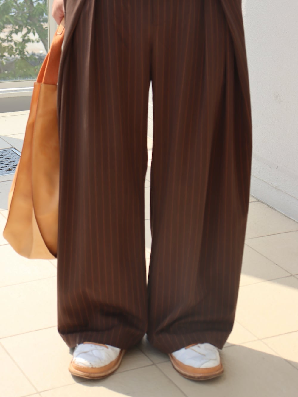 ホワイト系のシャツ/ブラウス、ブラウン系のスラックス、オレンジ系のトートバッグを着用したメンズの秋コーディネートの3枚目の写真