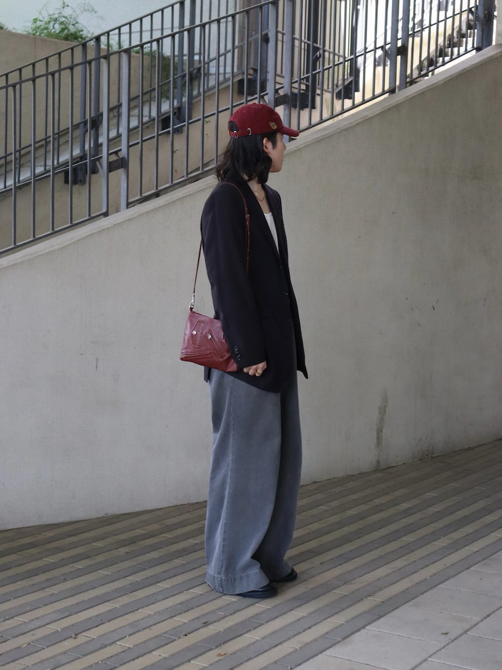 ホワイト系のタンクトップ、ブラック系のテーラードジャケット、レッド系のバッグを着用したメンズの春コーディネートの5枚目の写真