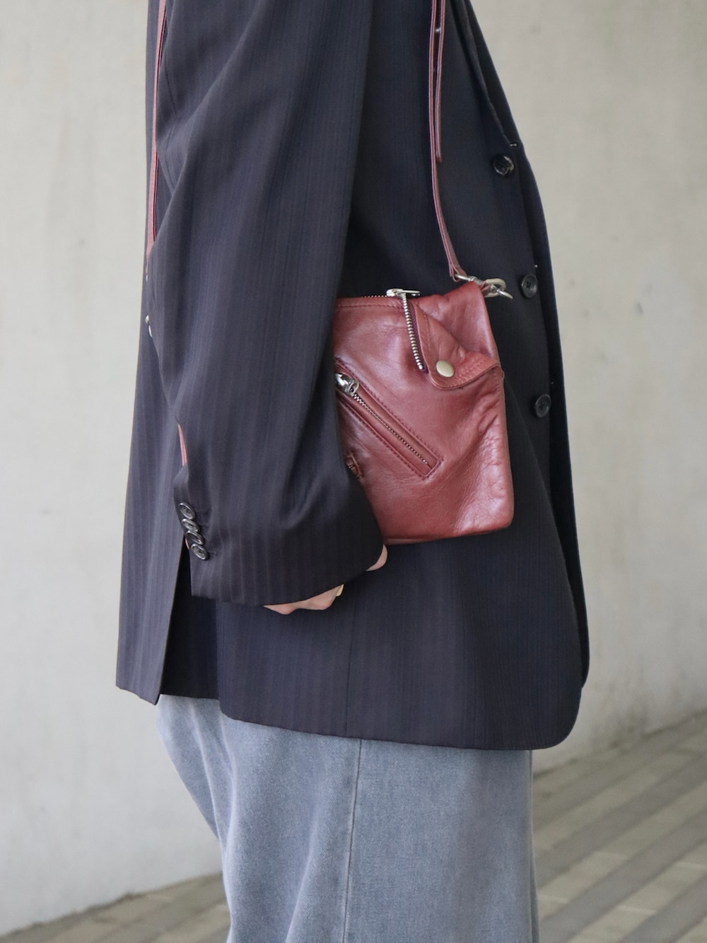 ホワイト系のタンクトップ、ブラック系のテーラードジャケット、レッド系のバッグを着用したメンズの春コーディネートの2枚目の写真