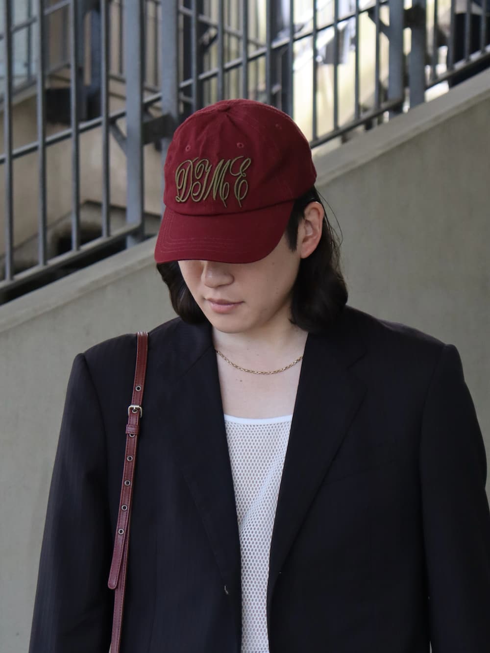 ホワイト系のタンクトップ、ブラック系のテーラードジャケット、レッド系のバッグを着用したメンズの春コーディネートの3枚目の写真