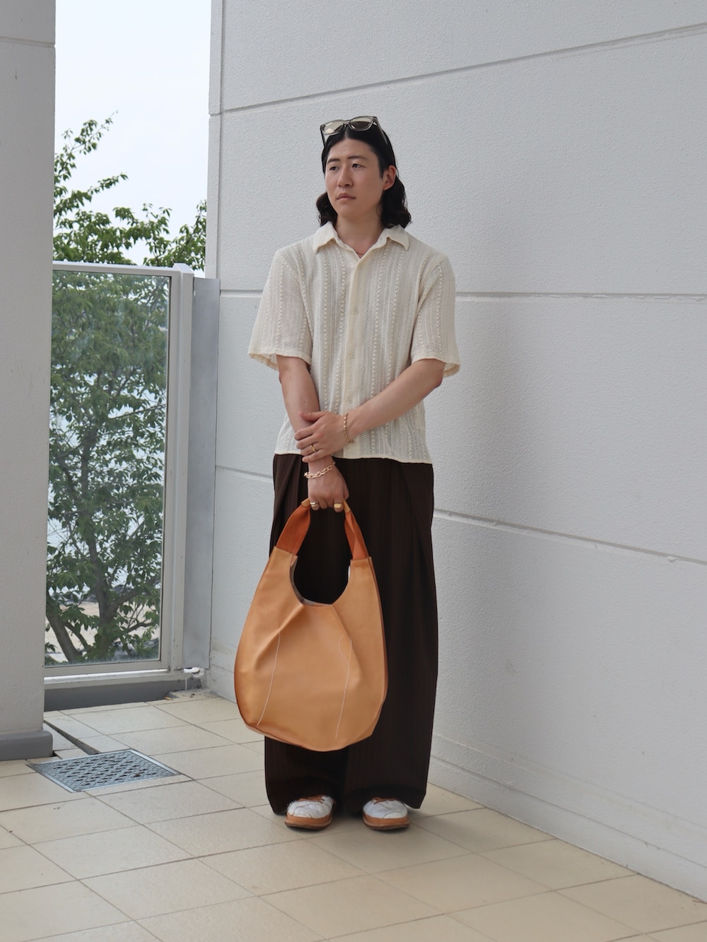 ホワイト系のシャツ/ブラウス、ブラウン系のスラックス、オレンジ系のトートバッグを着用したメンズの秋コーディネートの5枚目の写真