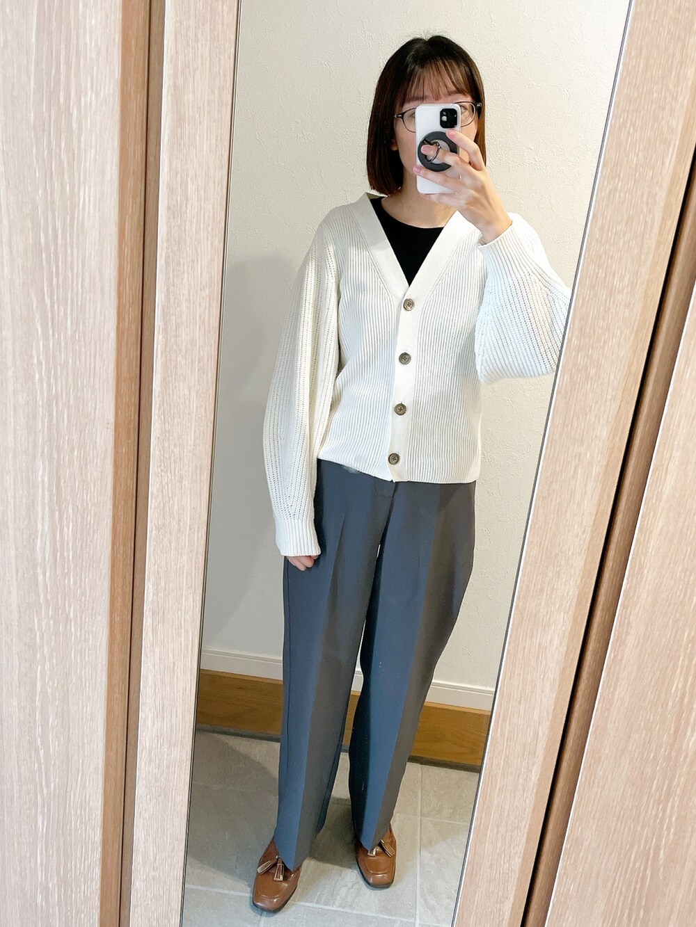 ブラウン系のローファー、グレー系のスラックス、ホワイト系のカーディガン/ボレロを着用したレディースの秋コーディネートの2枚目の写真