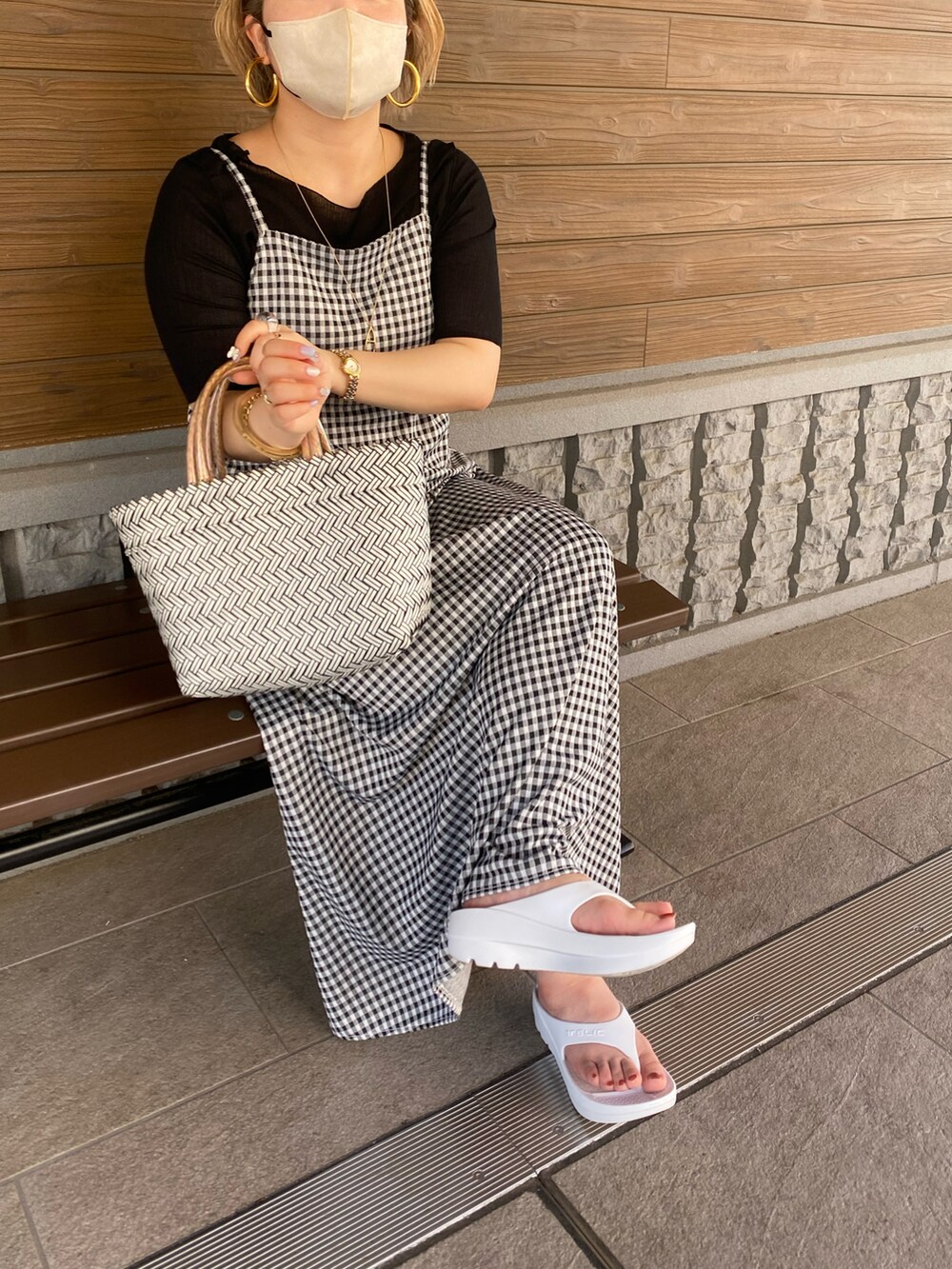 ブラック系のワンピース、ブラック系のTシャツ/カットソー、ホワイト系のサンダルを着用したレディースの夏コーディネートの3枚目の写真