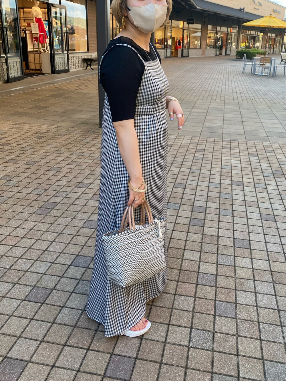 ブラック系のワンピース、ブラック系のTシャツ/カットソー、ホワイト系のサンダルを着用したレディースの夏コーディネートの2枚目の写真